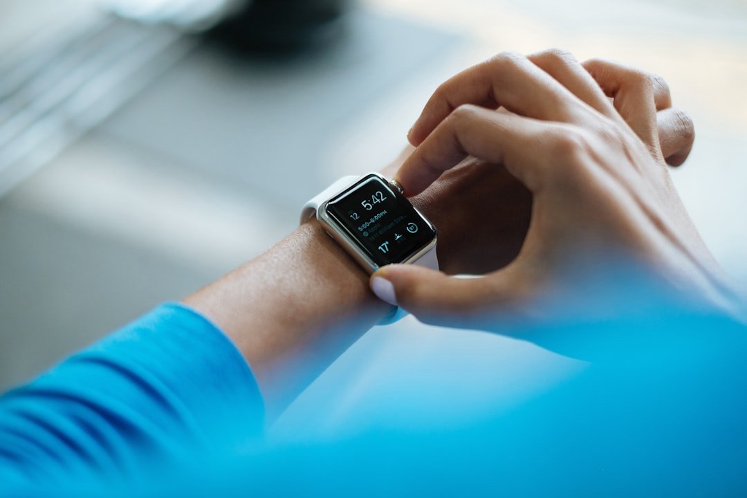 A close-up of a fitness tracker on a wrist, displaying activity metrics with a blurred background of a person exercising.