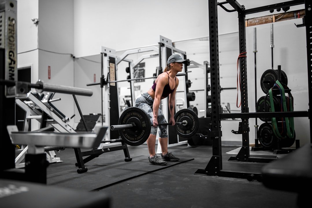 A woman lifting weights in a gym setting, showcasing strength training exercises.