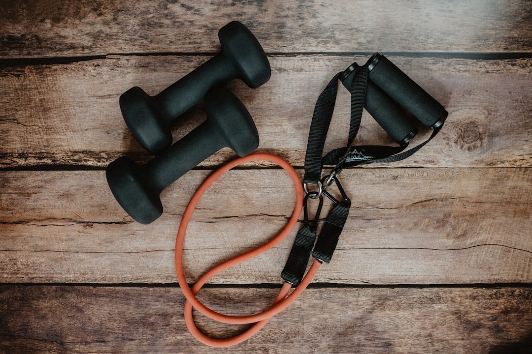 A woman using portable workout accessories in a park setting, showcasing fitness tools like resistance bands and yoga mats.