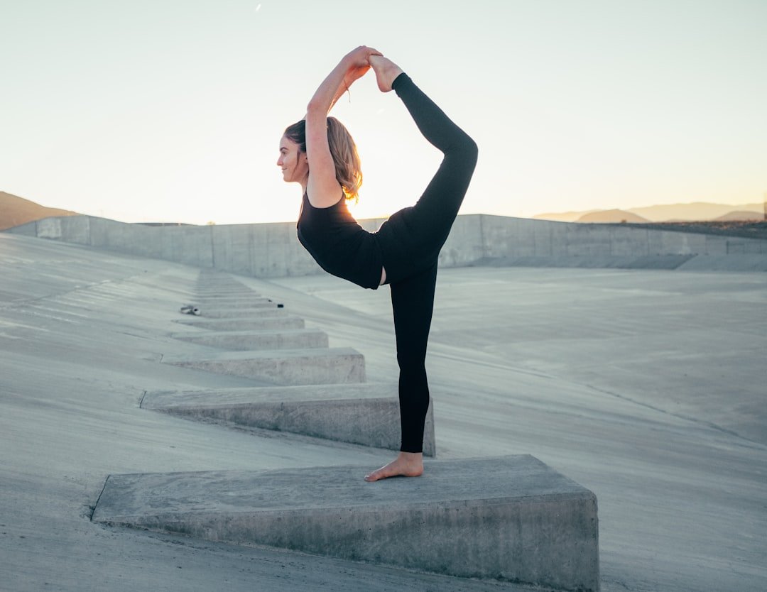 A person practicing yoga or stretching in a serene outdoor setting, showcasing balance and flexibility.