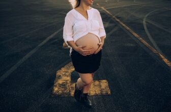 A pregnant woman practicing yoga in a serene outdoor setting, showcasing a healthy and active lifestyle during pregnancy.