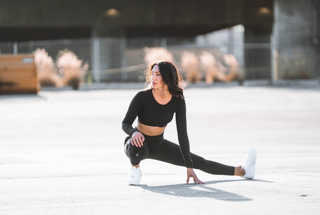 A person performing dynamic stretches in a gym setting, focusing on mobility and muscle activation before a workout.
