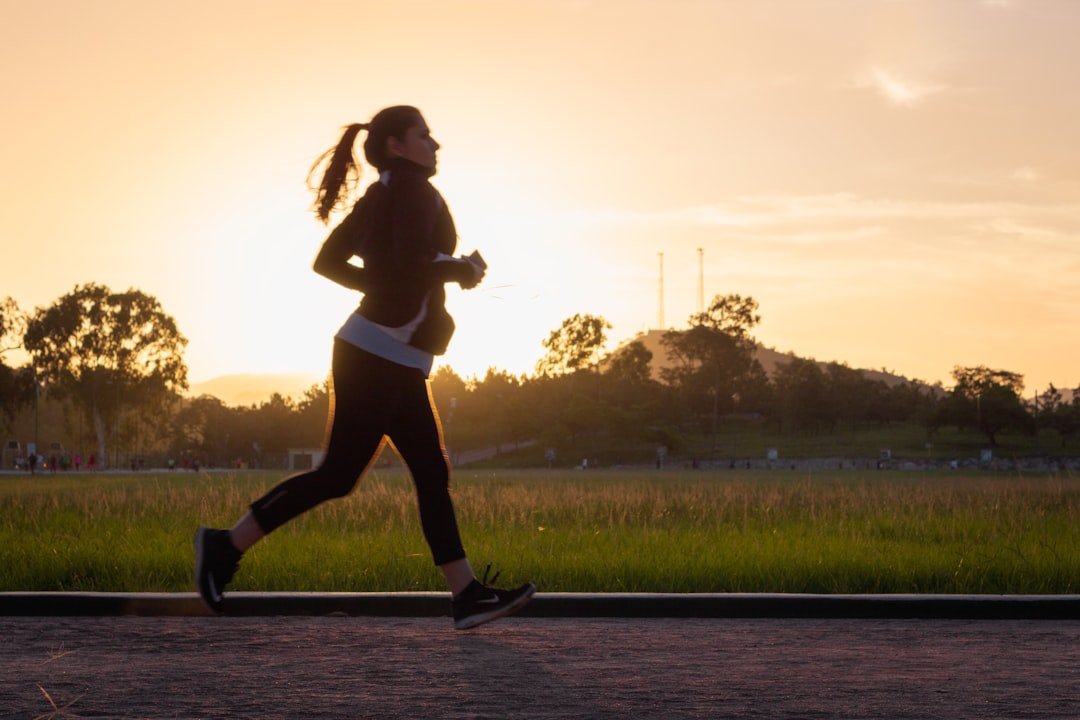 A person walking on a scenic path surrounded by nature, emphasizing fitness and outdoor activity.